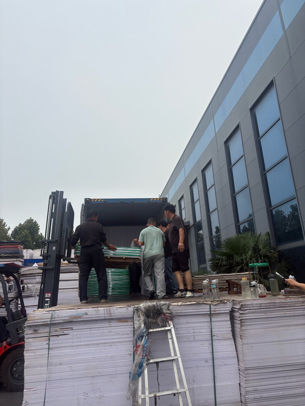 Workers loading PVC foam board into shipping container at Tianbei factory